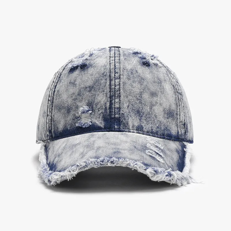 Acid wash denim baseball cap with frayed details and distressed rips.