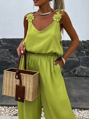 Yellow green wide-leg jumpsuit with floral applique straps and blouson waist.