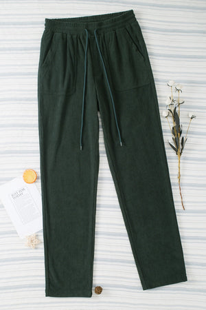 Dark Green corduroy drawstring trousers with slant pockets and a relaxed fit.