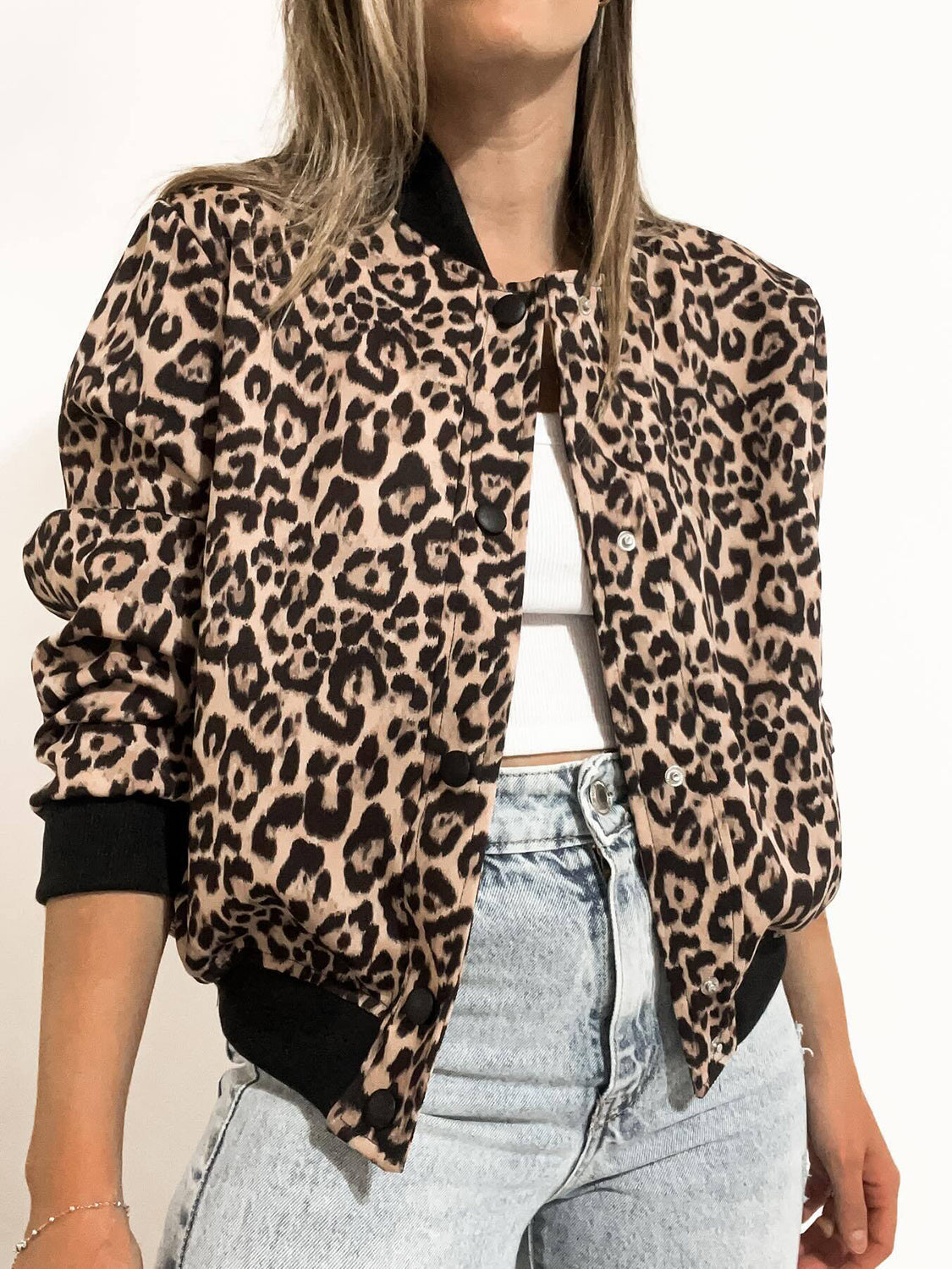 Leopard print bomber jacket with black collar and cuffs, button front, and pockets.