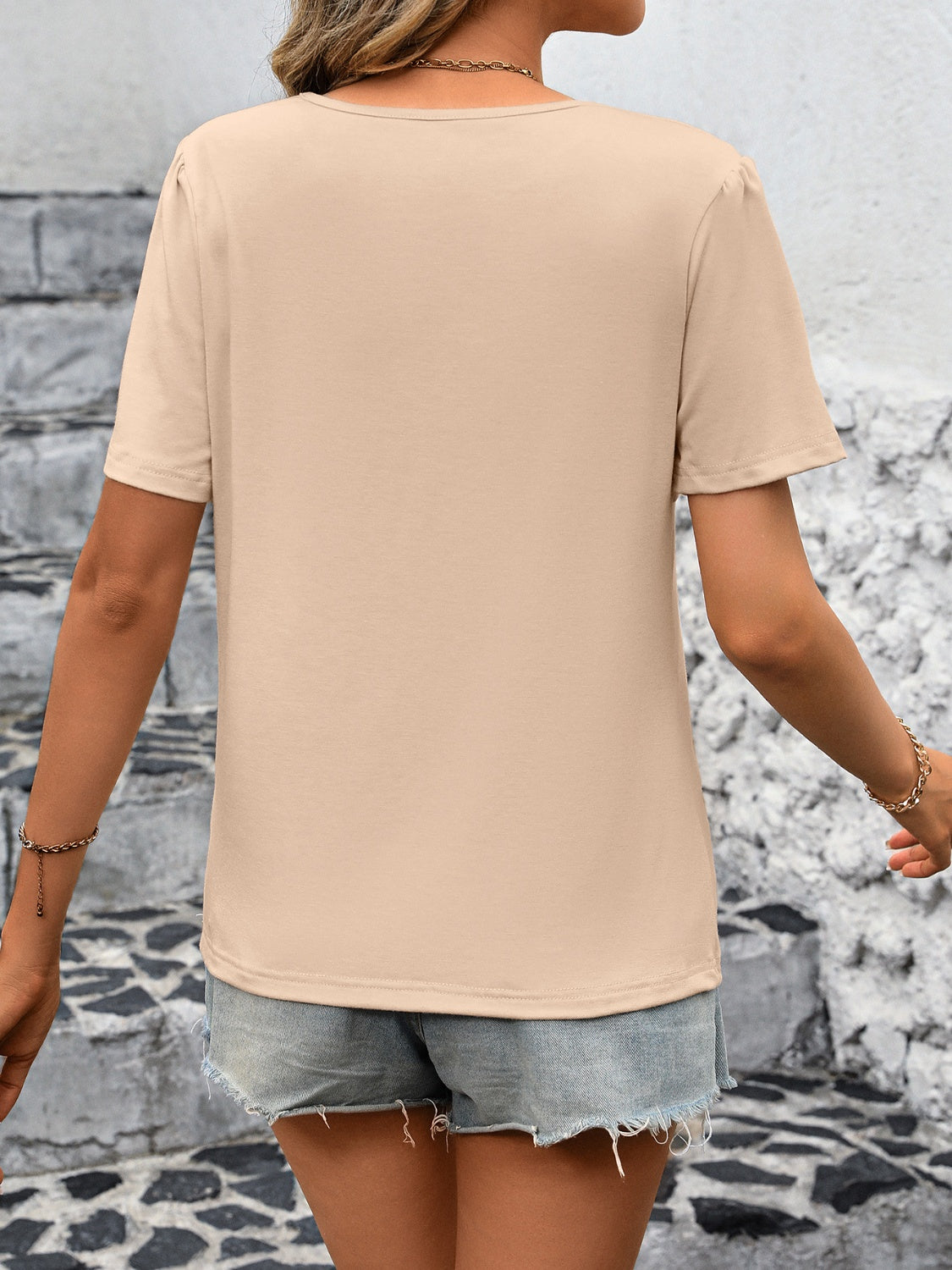 Tan jersey top with pleated cap sleeves and a scoop neck, shown from the back.
