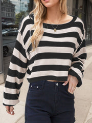 Black and beige striped knit sweater with off-shoulder neckline and cropped length.
