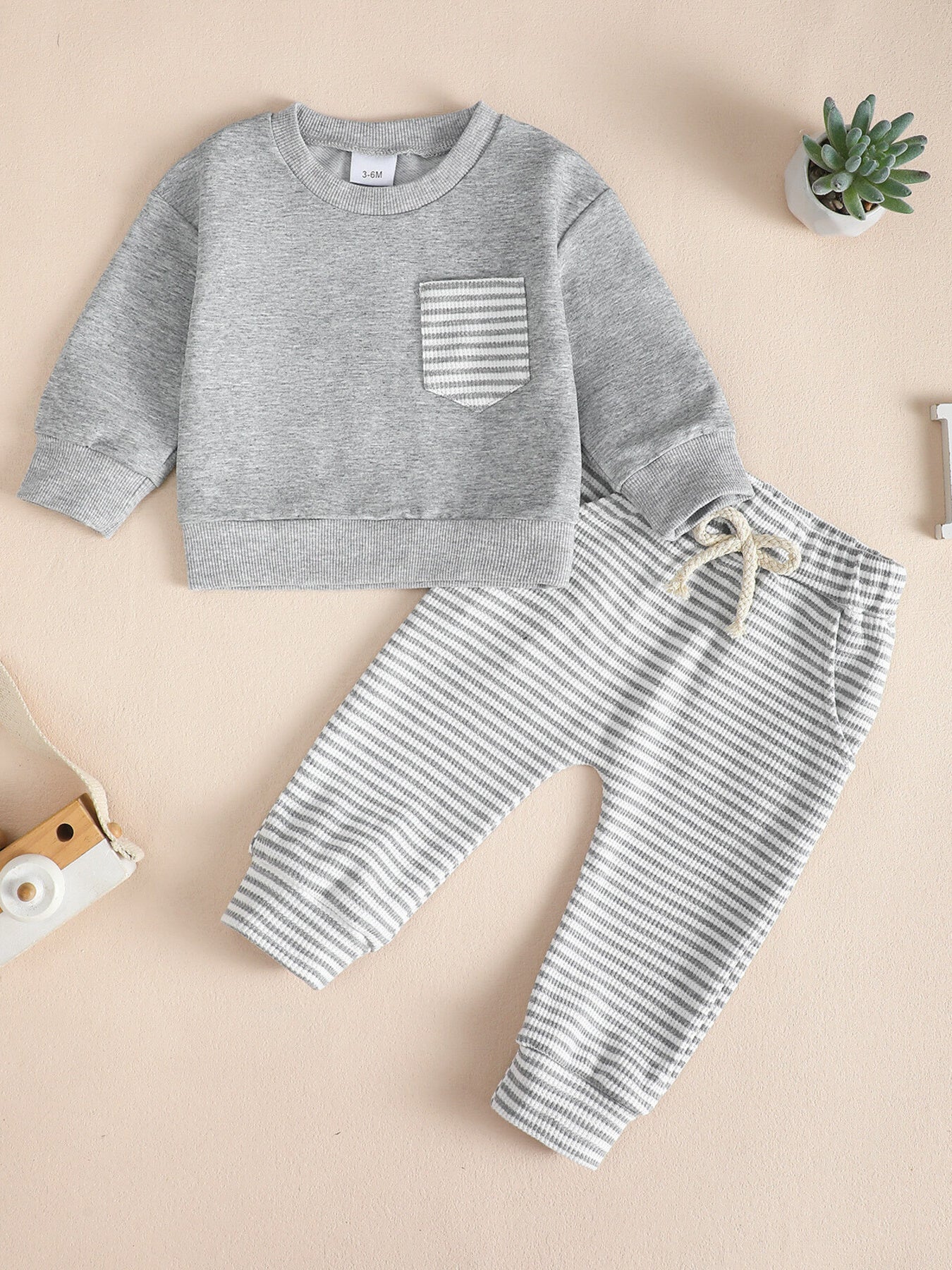 Children's grey cotton sweatshirt with striped pocket and matching striped pants with drawstring.