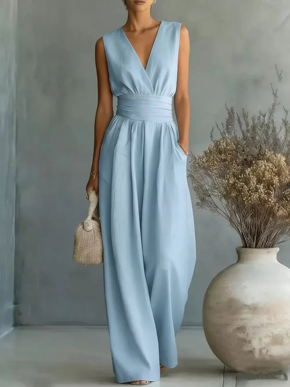 Sky blue sleeveless wide-leg jumpsuit with V-neck, cinched waist, and pockets.