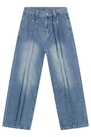 Medium wash denim trousers with vertical seams and a relaxed fit.