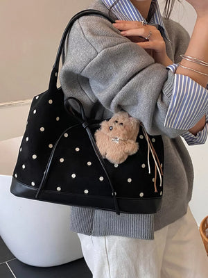 Black polka dot shoulder bag with bow detail and fuzzy charm