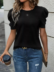 Black t-shirt with puff sleeves and a round neckline, styled with jeans and a clutch.