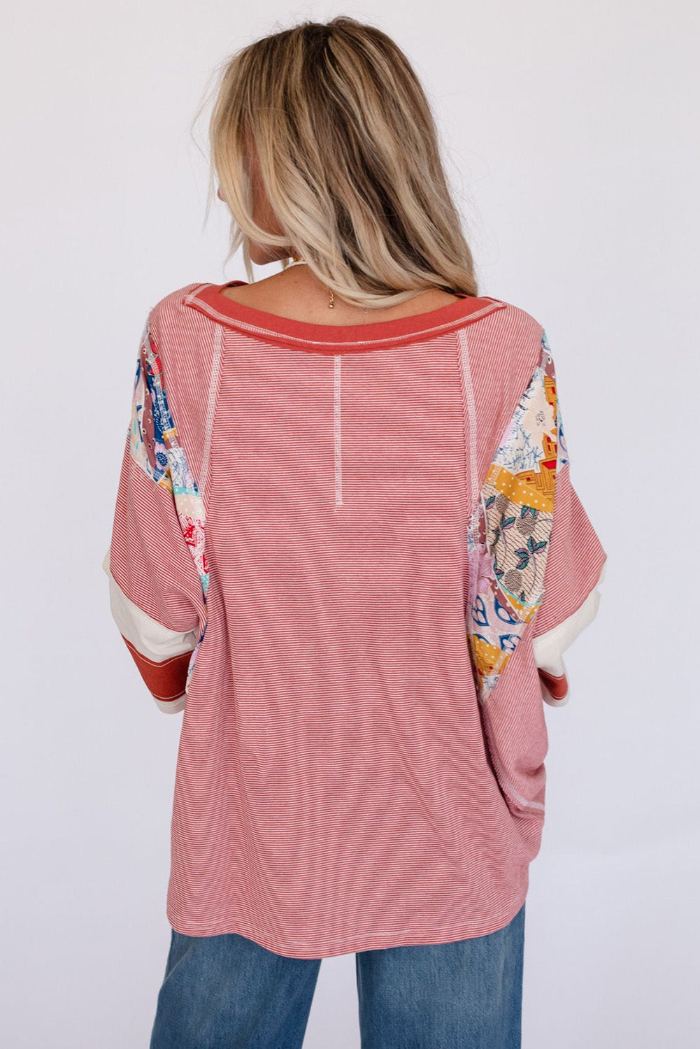 Patchwork stripe raglan tee in deep red with colorful patchwork sleeve details and a relaxed fit.