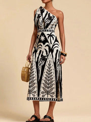Tropical print one-shoulder midi dress with defined waist and side slits.