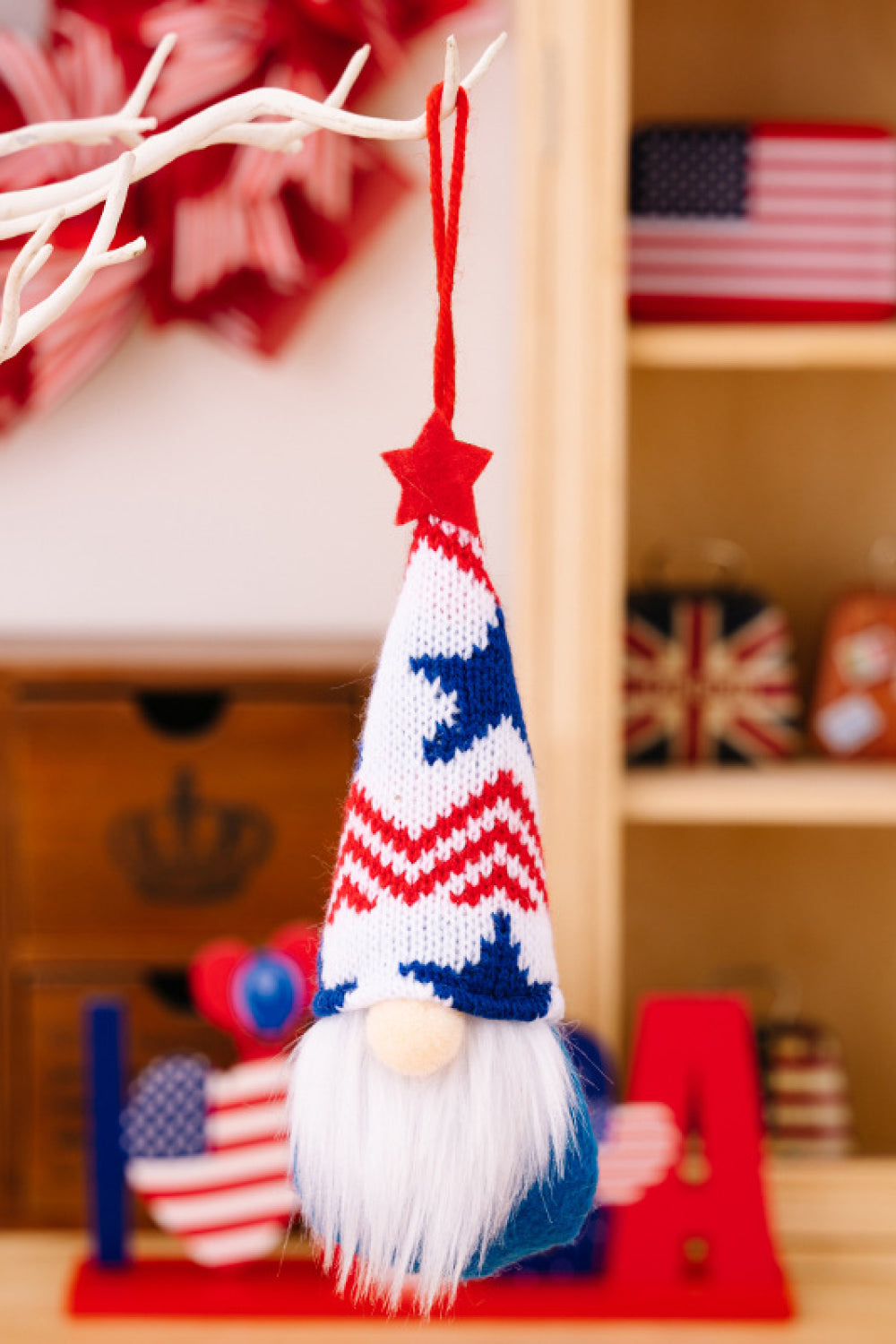 Patriotic knit gnome ornament with red, white, and blue striped hat and white beard.