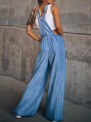 Denim overalls palazzo jumpsuit in light wash with wide legs and adjustable straps.