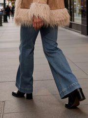 Baby girls' blue denim flare jeans with button closure and wide leg opening.