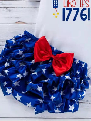 Ruffled bloomer with white stars on blue fabric and a red bow.