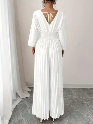 White pleated wide-leg jumpsuit with cinched waist and tie-back V-neck.