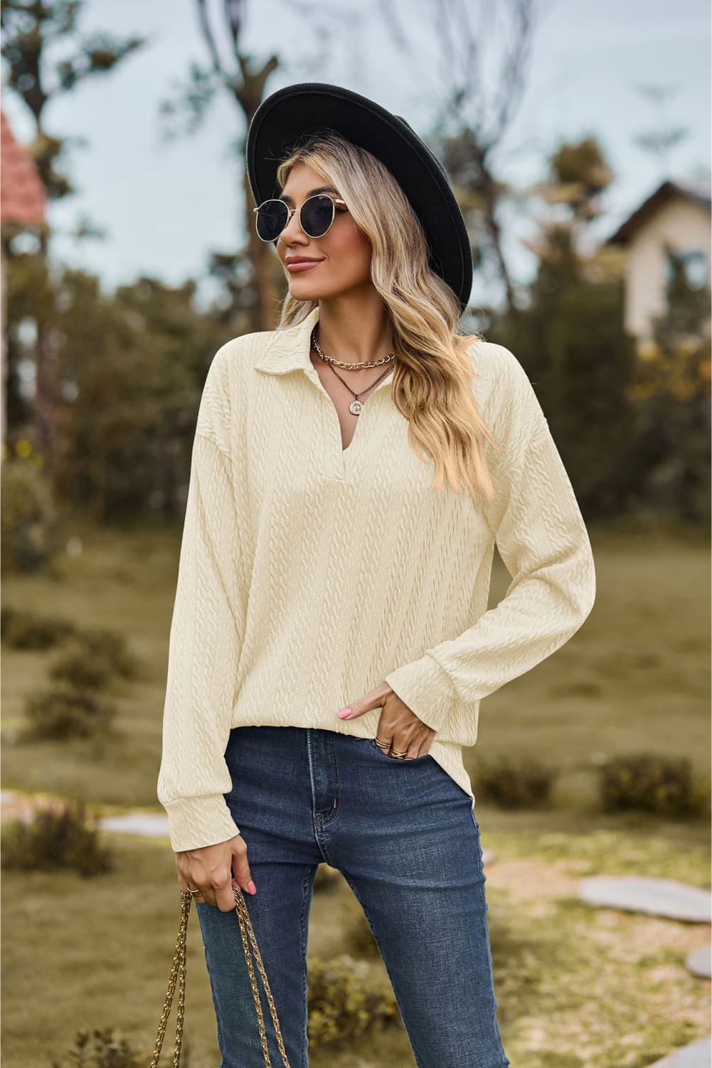 Ivory textured cable knit polo top with a V-neck and long sleeves.