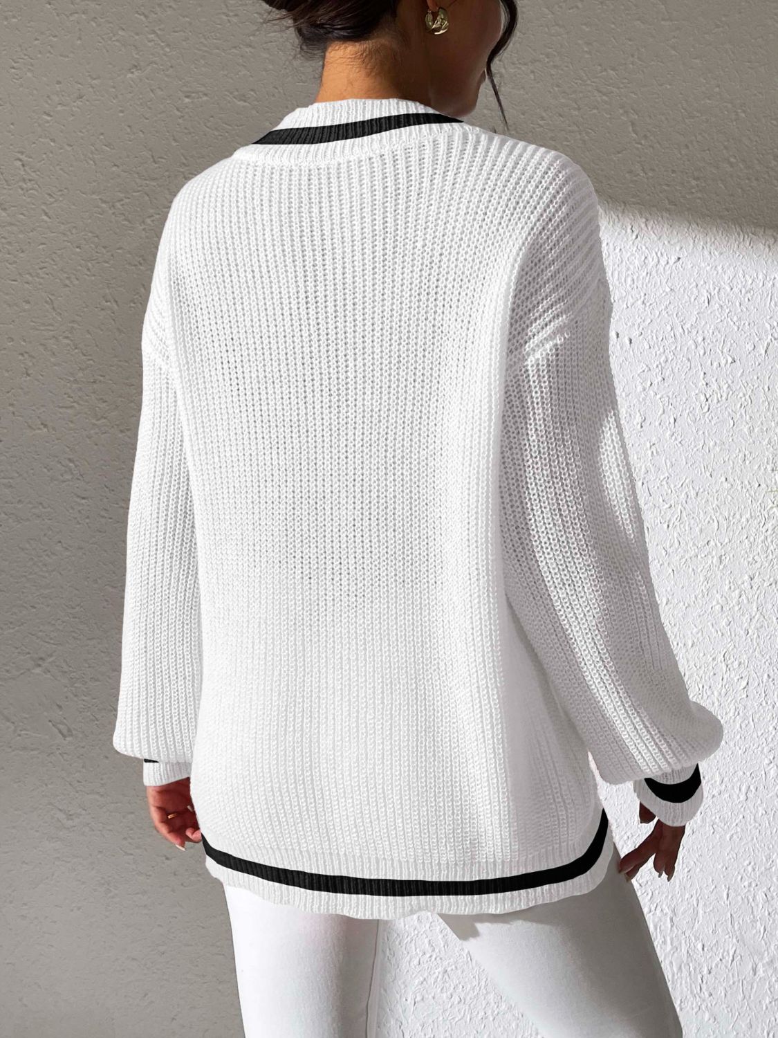 White ribbed knit sweater with black varsity trim on neckline and hem.