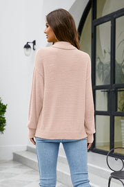 Blush pink textured turtleneck sweater with a relaxed fit.