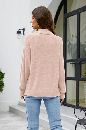 Blush pink textured turtleneck sweater with a relaxed fit.