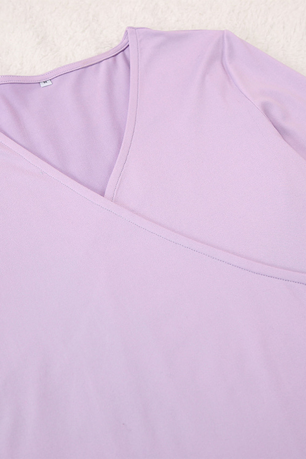 Draped wrap top in light purple with V-neck and subtle stitching detail.