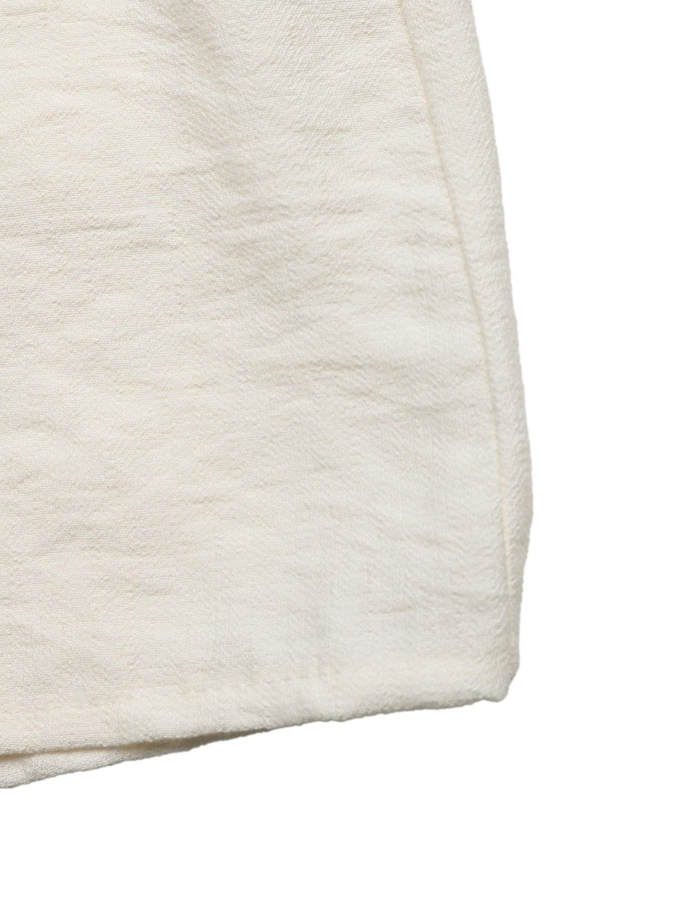 Beige tiered midi skirt with wavy trim detail and textured fabric.