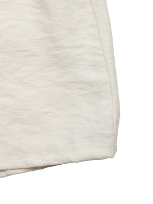 Beige tiered midi skirt with wavy trim detail and textured fabric.
