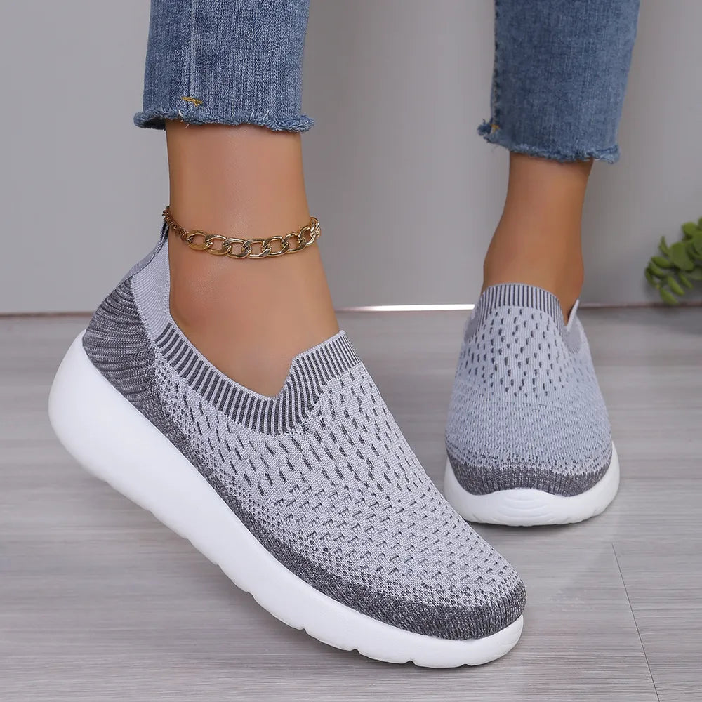 Light gray knit slip-on sneakers with sculpted white sole and textured pattern.
