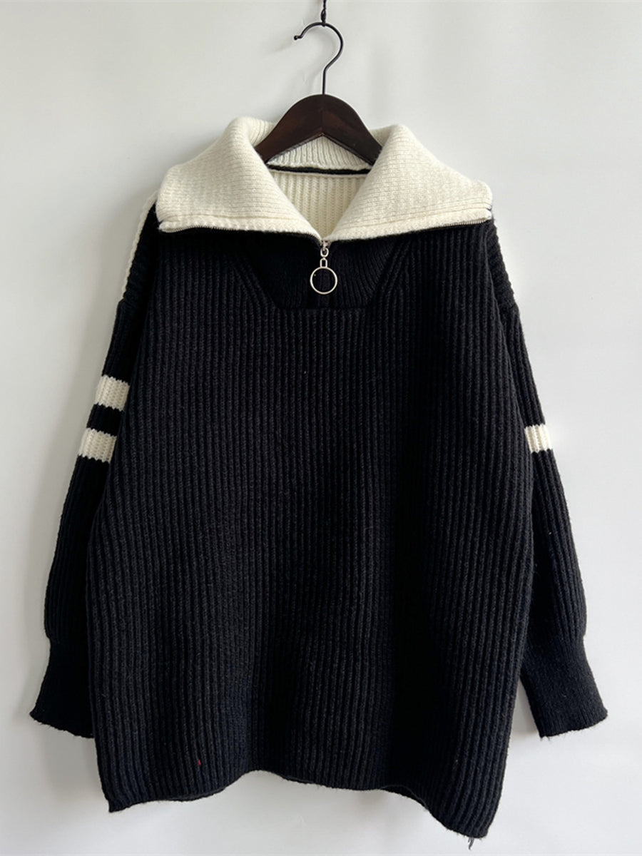 Black acrylic sweater with ribbed texture, white collar, quarter zip, and white sleeve stripes.