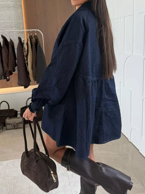 Dark blue denim mini dress with smocked cuffs and tiered skirt.