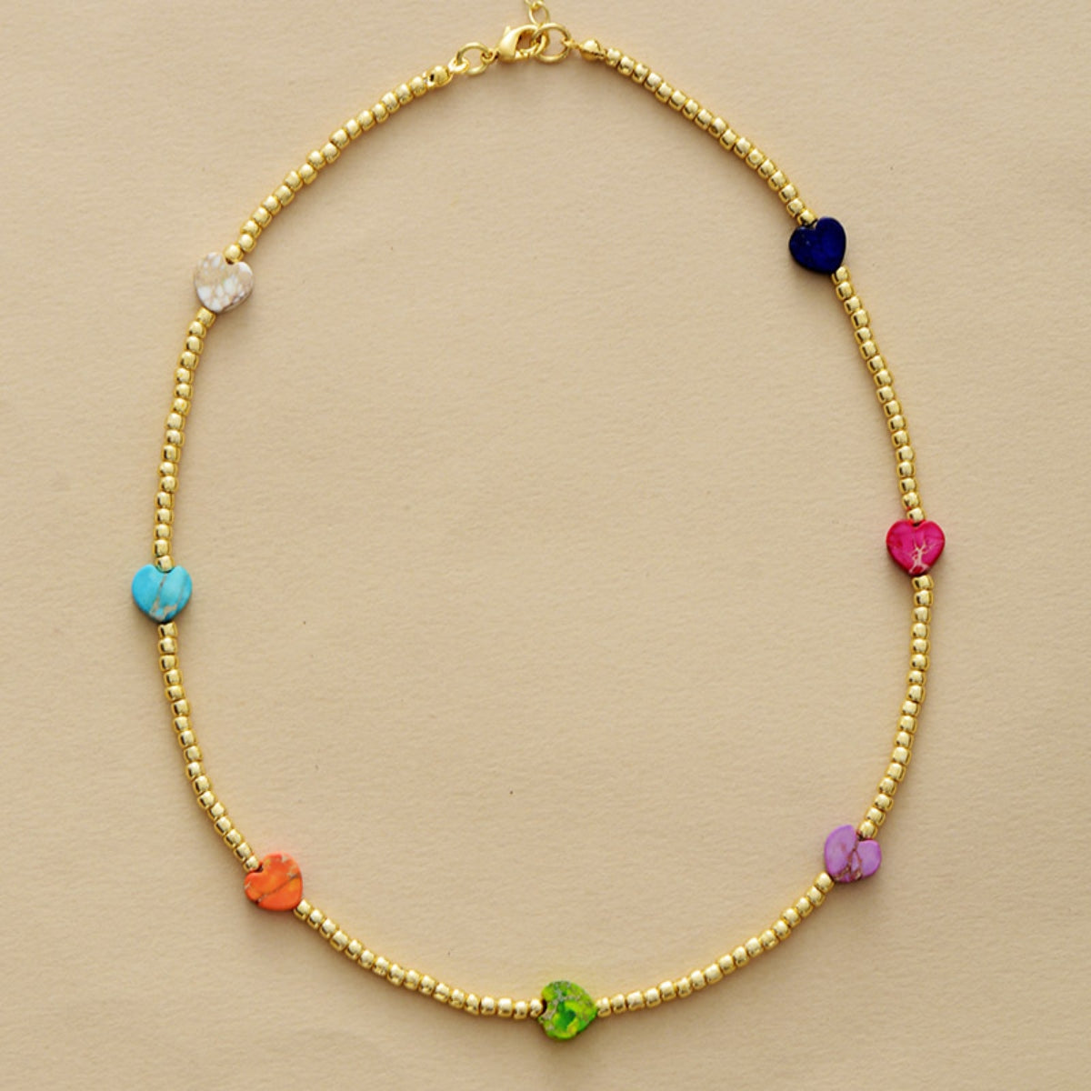 Gold beaded necklace with multicolor heart charms