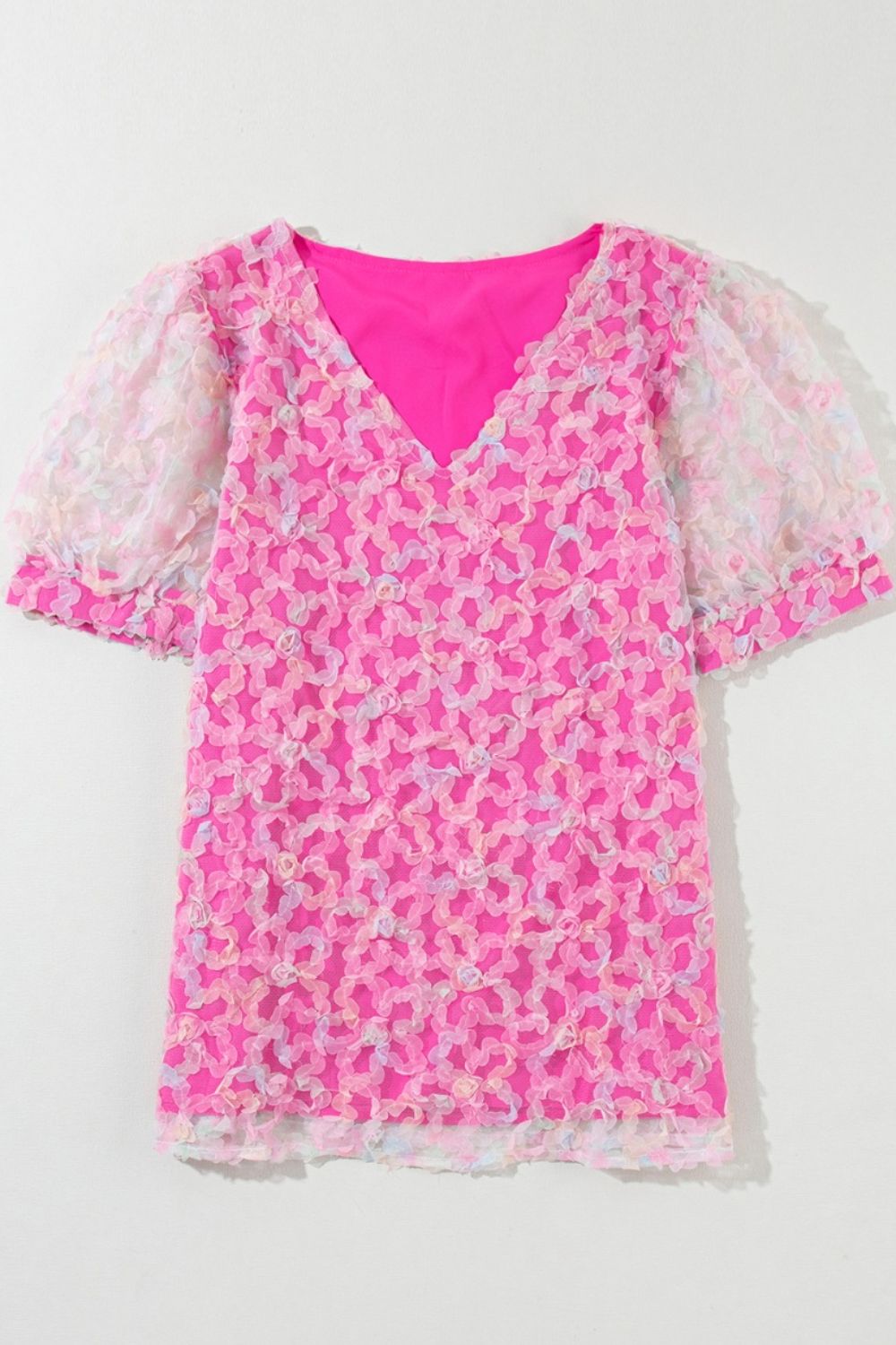 Fuchsia pink blouse with floral appliqué mesh puff sleeves and V-neck.