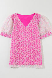 Fuchsia pink blouse with floral appliqué mesh puff sleeves and V-neck.
