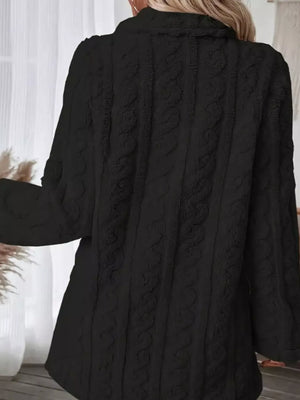 Black faux shearling coat with cable knit texture and double-breasted detail.