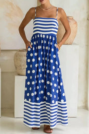 Blue polka dot maxi dress with spaghetti straps, striped bodice and hem, pockets.