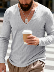 Light gray ribbed long sleeve t-shirt with a deep V-neck, worn by a man holding a coffee cup.