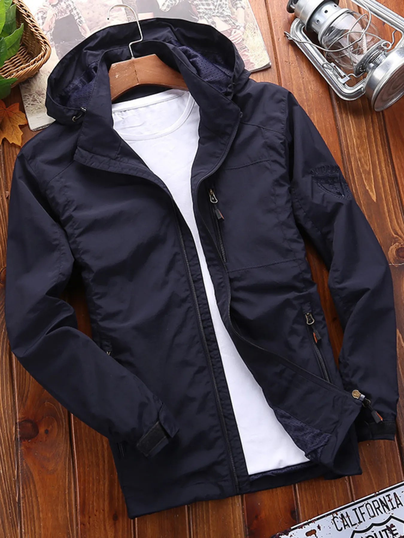 Men's navy blue lightweight hooded jacket with zip pockets and a casual fit.
