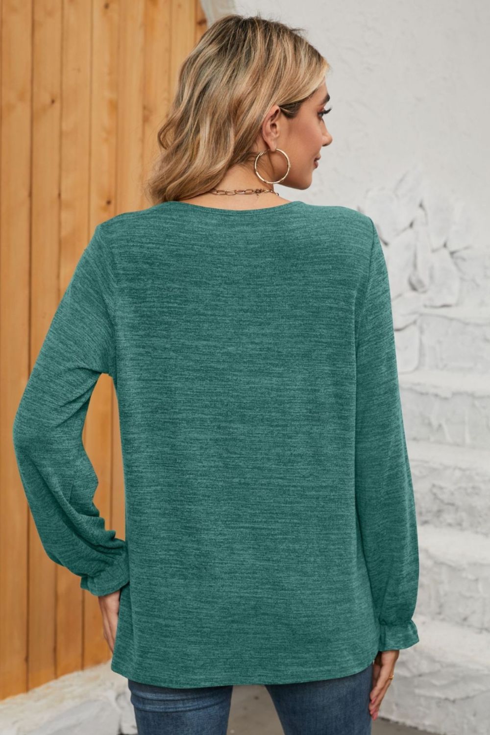 Teal knit top with ruffled cuffs and long sleeves, showing the back.