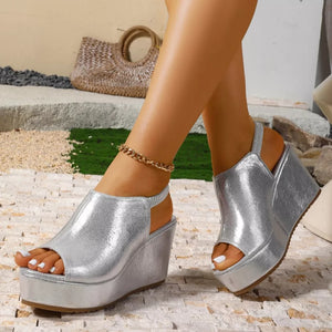 Sleek silver high heel wedge sandals with peep toe and slingback strap.