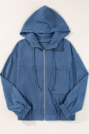 Dusty blue corduroy bomber hoodie with zip front, drawstring hood, and chest pocket.