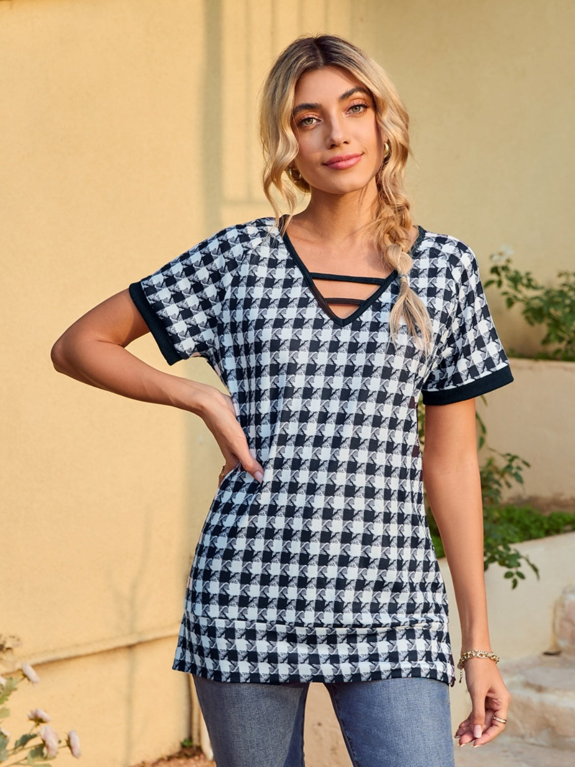 Houndstooth tunic top with cutout neckline and short sleeves.