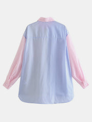 Colorblock striped oversized button-down shirt in blush pink and light blue with button cuffs.