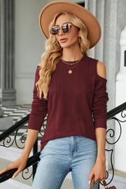 Burgundy textured cable knit cold shoulder top with long sleeves.