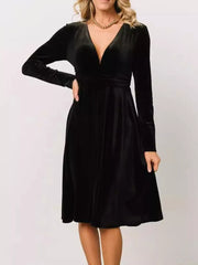 Black velvet midi dress with long sleeves and deep V-neck.
