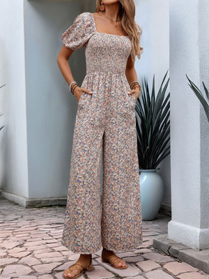 Floral smocked bodice wide leg jumpsuit with puff sleeves and square neckline.