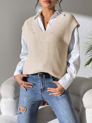 Beige ribbed knit V-neck sleeveless vest with pearl embellishments over a white shirt.