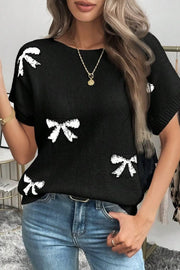 Black knit tunic with white bow motif, short sleeves, and crew neck.