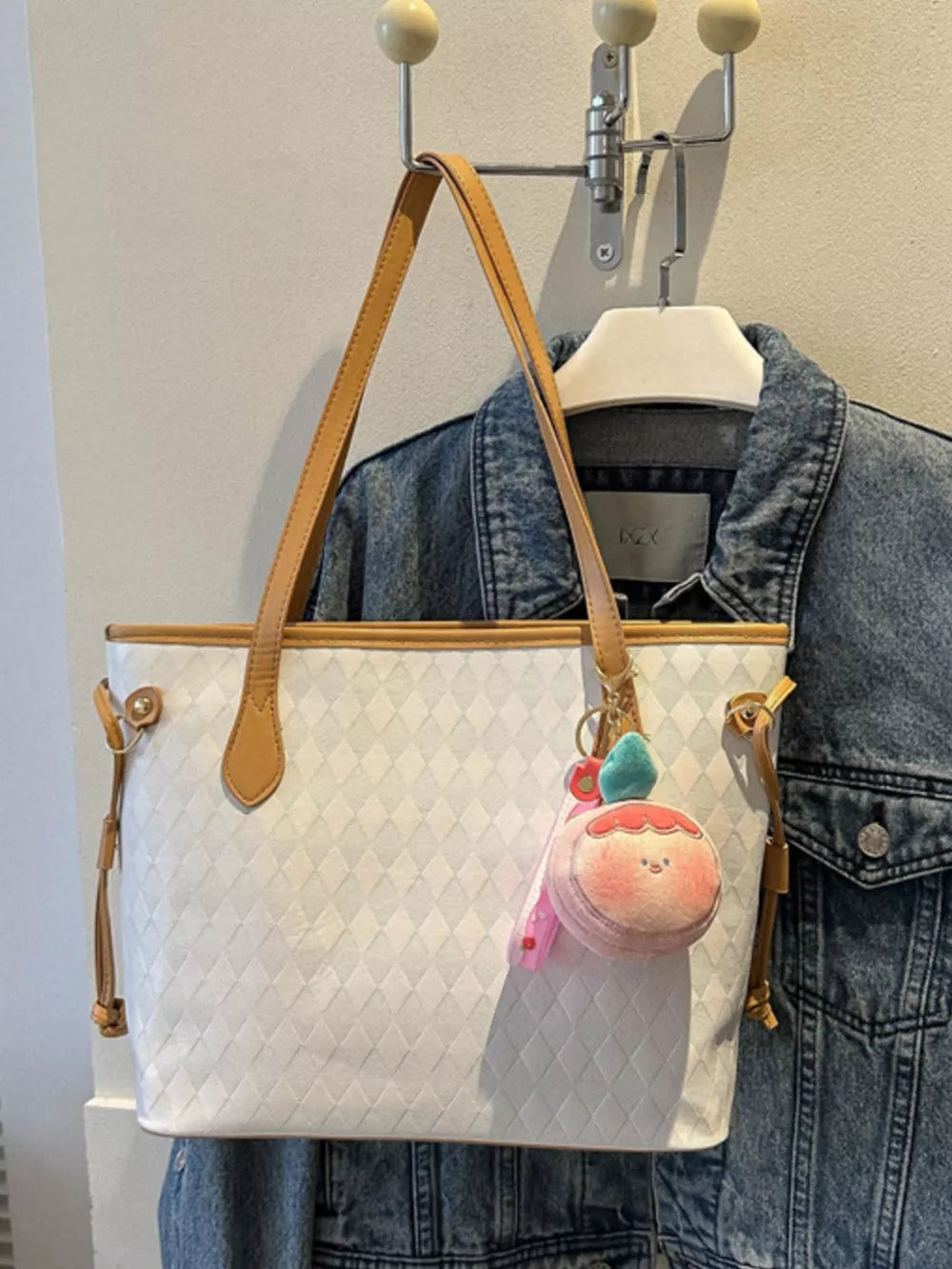 Textured diamond woven tote bag in white with tan straps and a cute peach charm.
