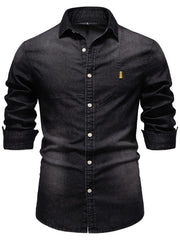Dark denim button-down shirt with asymmetric pocket detail and rolled sleeves.