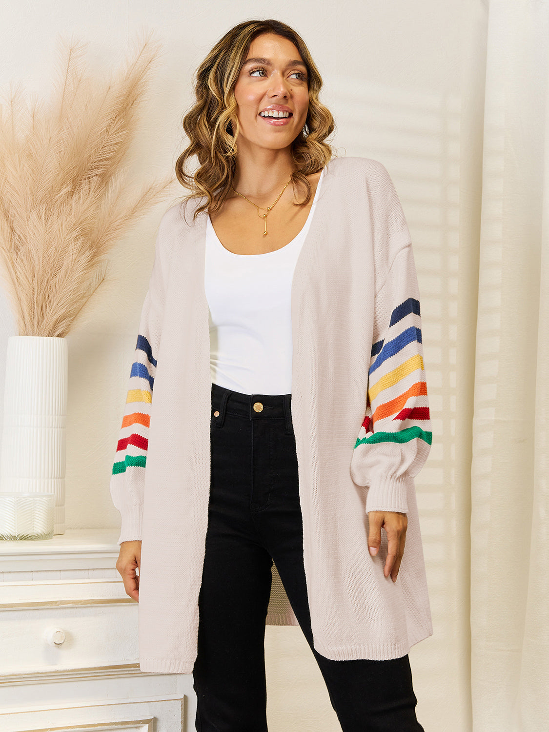Open-front knit cardigan in tan with rainbow striped balloon sleeves.