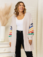 Open-front knit cardigan in tan with rainbow striped balloon sleeves.