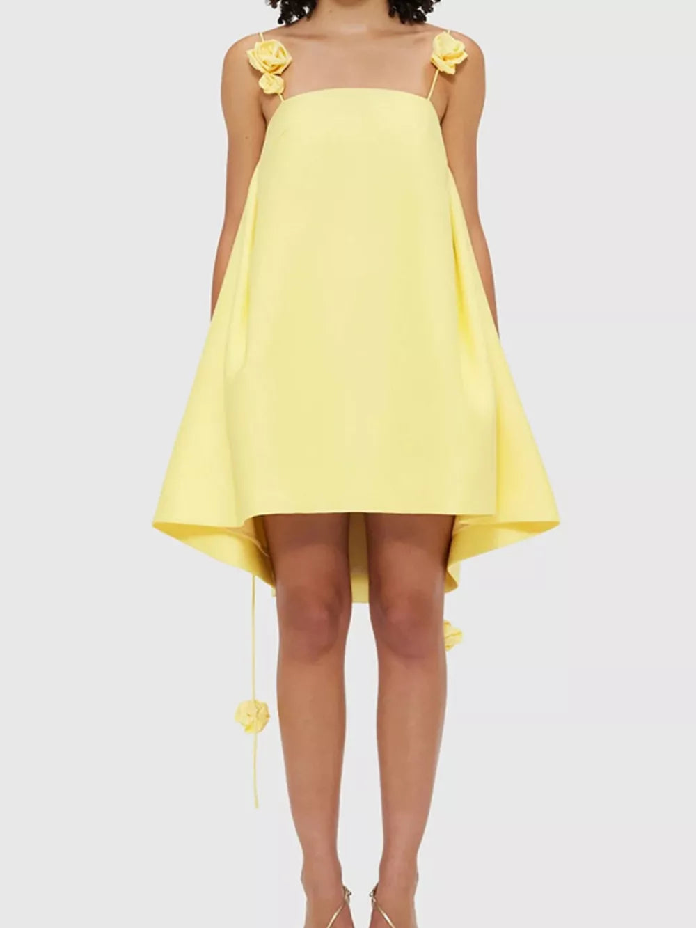 Yellow A-line mini dress with floral applique straps and hem detail.